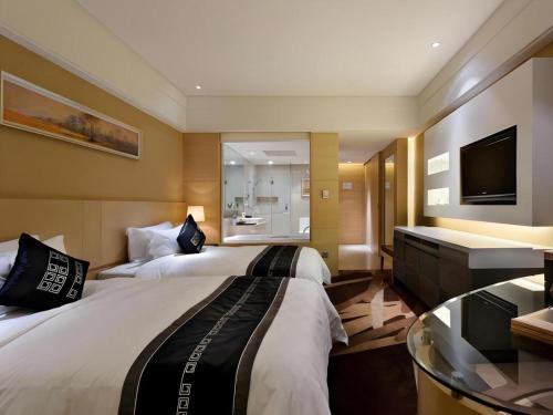 a hotel room with two beds and a television at Putian Depo Hotel in Putian