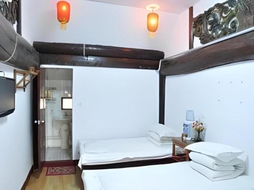 a room with two beds and a tv at Pingyao Yufengheng Hotel in Pingyao