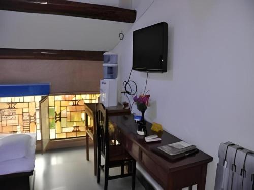 a room with a desk with a tv on the wall at Pingyao Yufengheng Hotel in Pingyao
