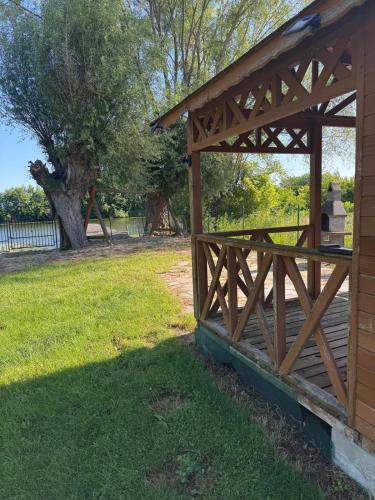 a wooden pavilion with a gate in a yard at Ku Jezioru in Pawłowice