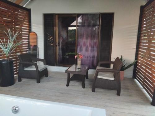 a living room with chairs and a table and a tub at Villa 820 in Pacific Harbour