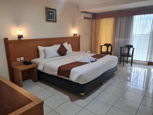 a bedroom with a large bed in a hotel room at Pondok Jatim Park Hotel & Cafe in Batu