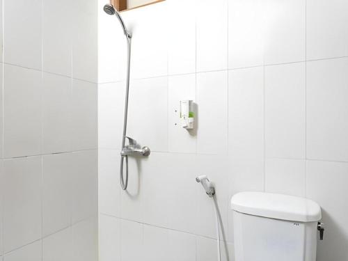a shower in a white bathroom with a toilet at Pondok Jatim Park Hotel & Cafe in Batu