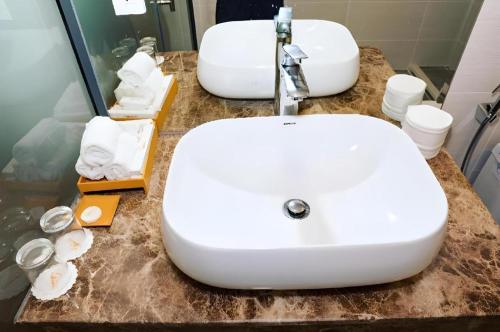 a bathroom with a white sink and a mirror at Gold View Boutique Hotel Đà Lạt in Da Lat