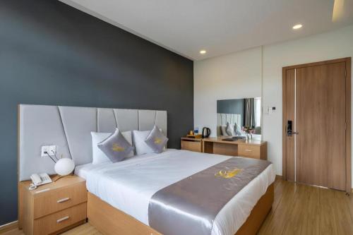 a bedroom with a large bed and a telephone at Gold View Boutique Hotel Đà Lạt in Da Lat