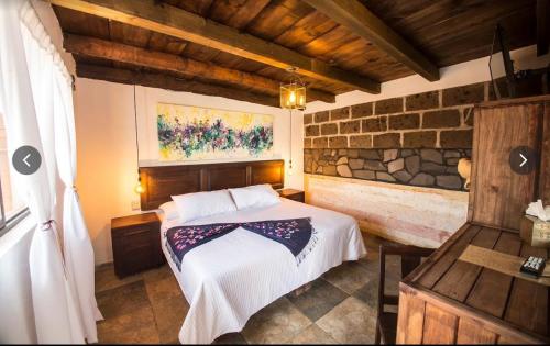 a bedroom with a bed and a stone wall at la casa positos in Guanajuato