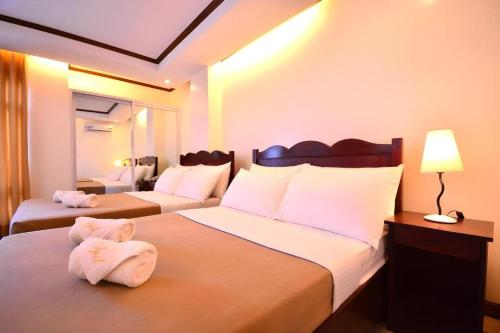 une chambre d'hôtel avec deux lits avec des serviettes dessus dans l'établissement Ipil Suites Puerto Princesa, à Puerto Princesa
