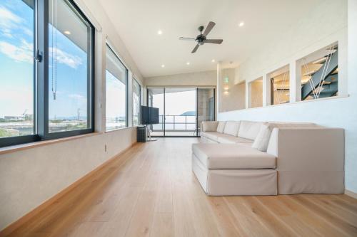 a living room with a white couch and windows at One's You Villa Awaji in Awaji