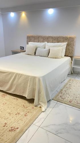 a bedroom with a large bed with white sheets and pillows at VILLA 200 Piscine in Kelibia