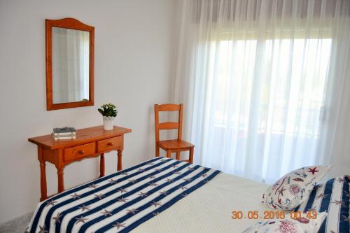sypialnia z łóżkiem, stołem i lustrem w obiekcie Apartamentos Montalvo Playa w mieście Montalvo