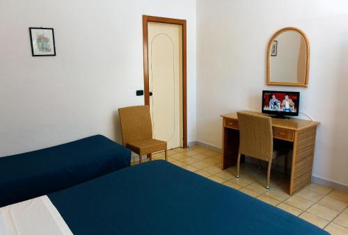 a hotel room with a desk and a bed and a mirror at Hotel Residence La Darsena in Agropoli