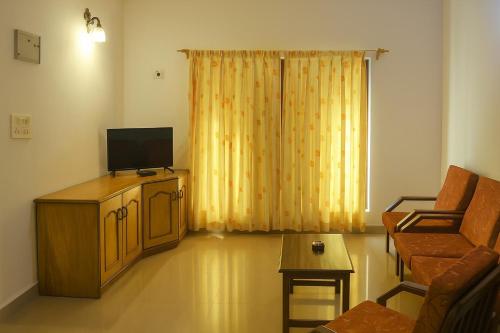 a living room with a television and a couch at Sonikas Holiday Homes (Studio) in Candolim