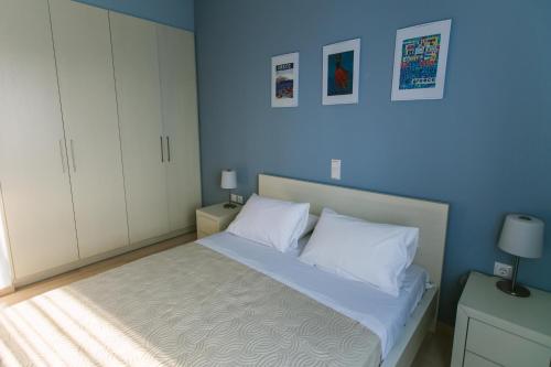 a bedroom with a bed with blue walls and white cabinets at Maistros Kardamyli Apartments in Kardamili