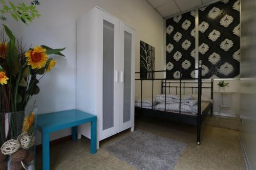 Piccola camera con tavolo blu e culla. di Panda Hostel a Milano
