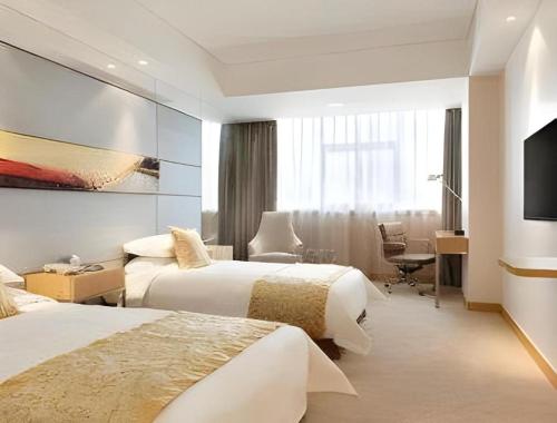 a hotel room with two beds and a television at Ramada Plaza by Wyndham Chuzhou in Chuzhou