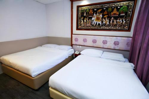 two beds in a room with purple curtains at Hotel 165 in Singapore