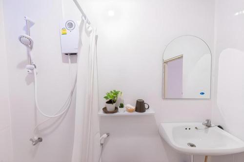 a white bathroom with a shower and a sink at THE GOOSE HOUSE UBON in Ubon Ratchathani