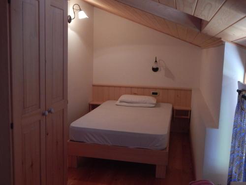 Dormitorio pequeño con cama en el ático en Casa Sassdei, en Cavedago