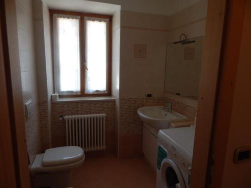 カヴェダーゴにあるCasa Sassdeiのバスルーム(トイレ、洗面台付)、窓が備わります。