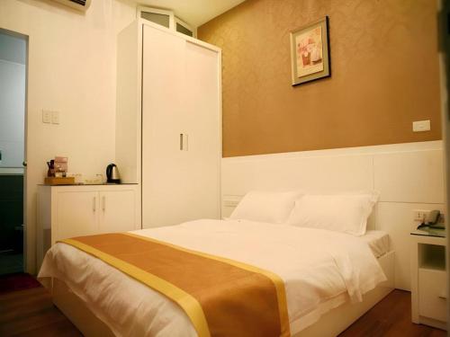 a bedroom with a large white bed with a cabinet at Hanoi Milan Hotel in Hanoi