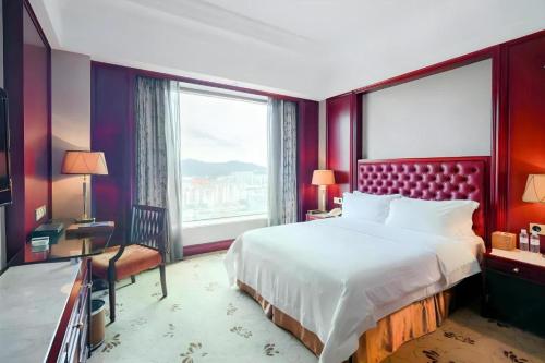 a bedroom with a large bed and a large window at King Century Hotel in Zhongshan