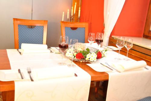 a table with wine glasses and a bowl of flowers at Weingasthof Zum weißen Roß in Osthofen