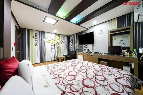 a bedroom with a large bed with a red and white blanket at Chuncheon World Hotel in Chuncheon