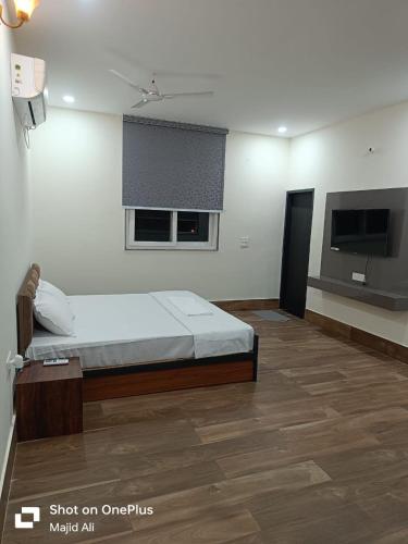 a bedroom with a bed and a flat screen tv at Rocopie Farm in Asthal Bohar