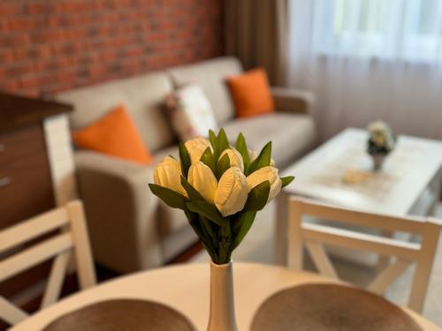 a vase with a yellow flower on a table at A&M Apartments - apartment Prostejovska in Prešov