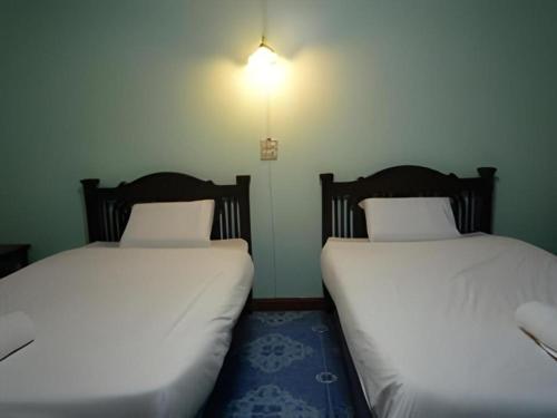 two beds sitting next to each other in a room at Erawan Place in Mae Sot