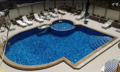 a large pool with blue water in a hotel room at One Sunny Home in Sunny Beach in Sunny Beach
