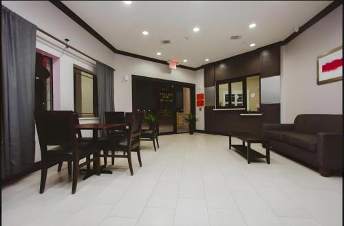 a living room with a table and chairs and a couch at Americas Best Value Inn and Suites IAH Airport North in Houston