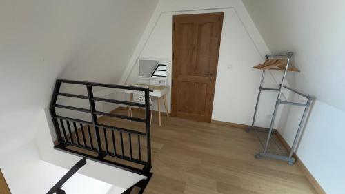 an attic room with a staircase and a stair case at La ferme Le Clos de la Becque in Muncq-Nieurlet