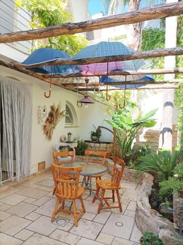 a patio with a table and chairs and umbrellas at Dimora Baronia in Latiano