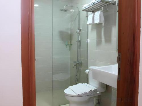 a bathroom with a shower and a toilet and a sink at Havana Mutiara Belitung in Tanjungpandan