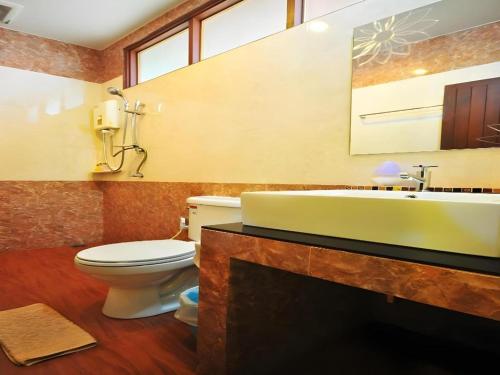 une salle de bain avec un lavabo, des toilettes et une baignoire dans l'établissement Baan Saranrom, à Amphawa