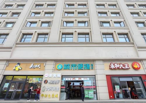 a large building with people standing outside of it at City Comfort Inn Wuhan Hankou Railway Station West Square in Wuhan