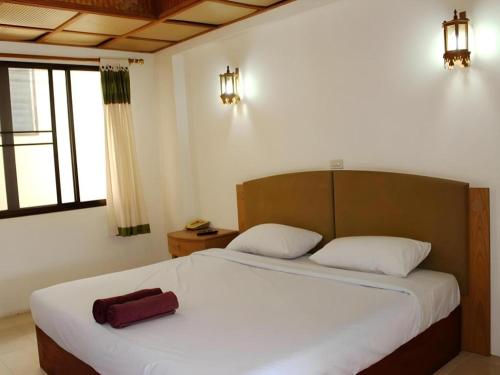 a bedroom with a large bed with a red bag on it at Panorama Hotel in Mae Hong Son