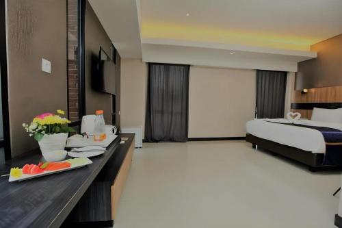 a hotel room with a bed and a table with food at Fitra Hotel Majalengka in Majalengka