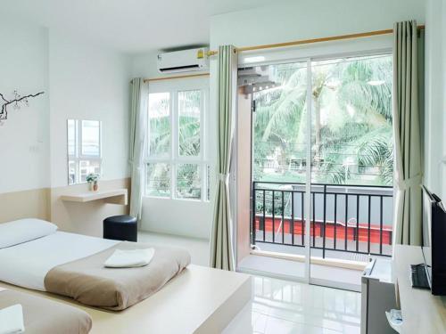 Un dormitorio con una cama y una ventana grande. en Cheaper Room, en Surat Thani