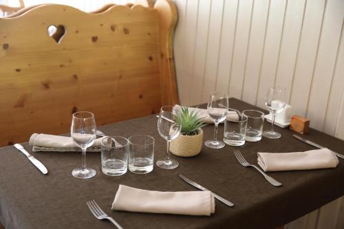 a table with wine glasses and silverware on it at La Ferme du Bois Barbu in Villard-de-Lans