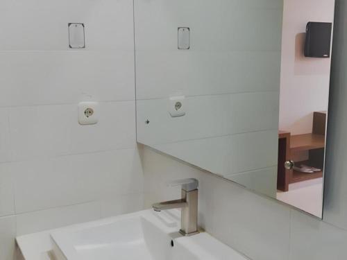 a bathroom with a mirror and a sink at Mataram Square Hotel in Gili Trawangan