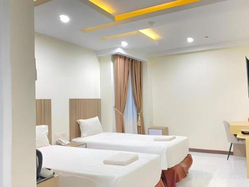 a hospital room with two beds and a desk at Hotel Grand Permata Hati in Banda Aceh