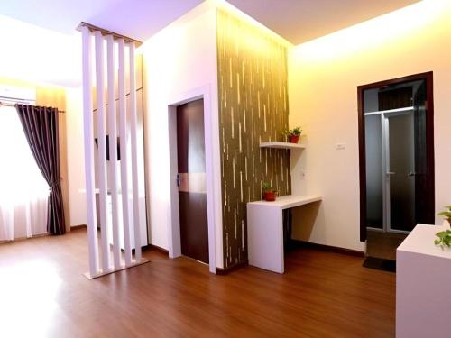 a room with white walls and wooden floors and a door at Hotel Grand Permata Hati in Banda Aceh
