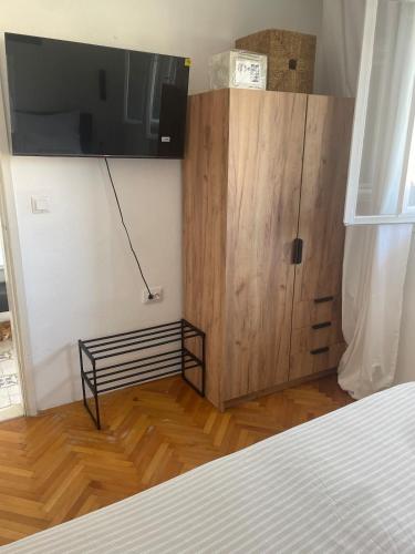 a bedroom with a bed and a cabinet with a television on it at Villa Mandarin in Opuzen