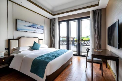 a hotel room with a large bed and a window at Poltton International Service Apartment Fujian Changtai Mayangxi in Zhangzhou