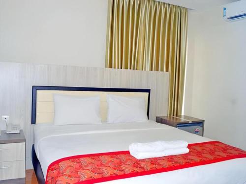 a bedroom with a bed with two towels on it at Grant Hotel Subang in Bandung