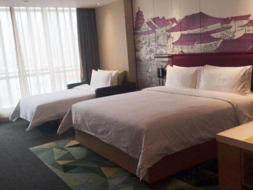 a hotel room with two beds and a large window at Hampton by Hilton Xi'an Dayan Pagoda in Xi'an