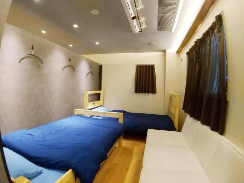 a bedroom with two blue beds in a room at Stay Chill Shinbashi in Tokyo