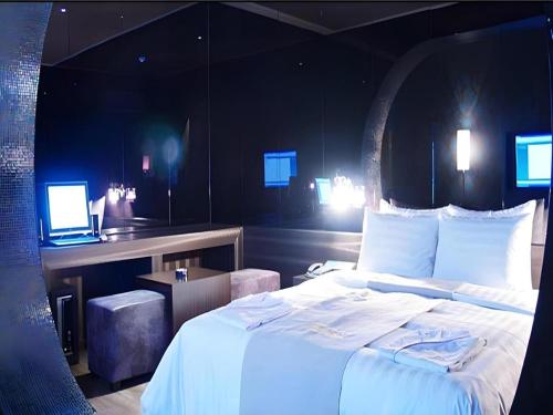 a bedroom with a bed and a desk with a laptop at Hotel Floce in Bucheon